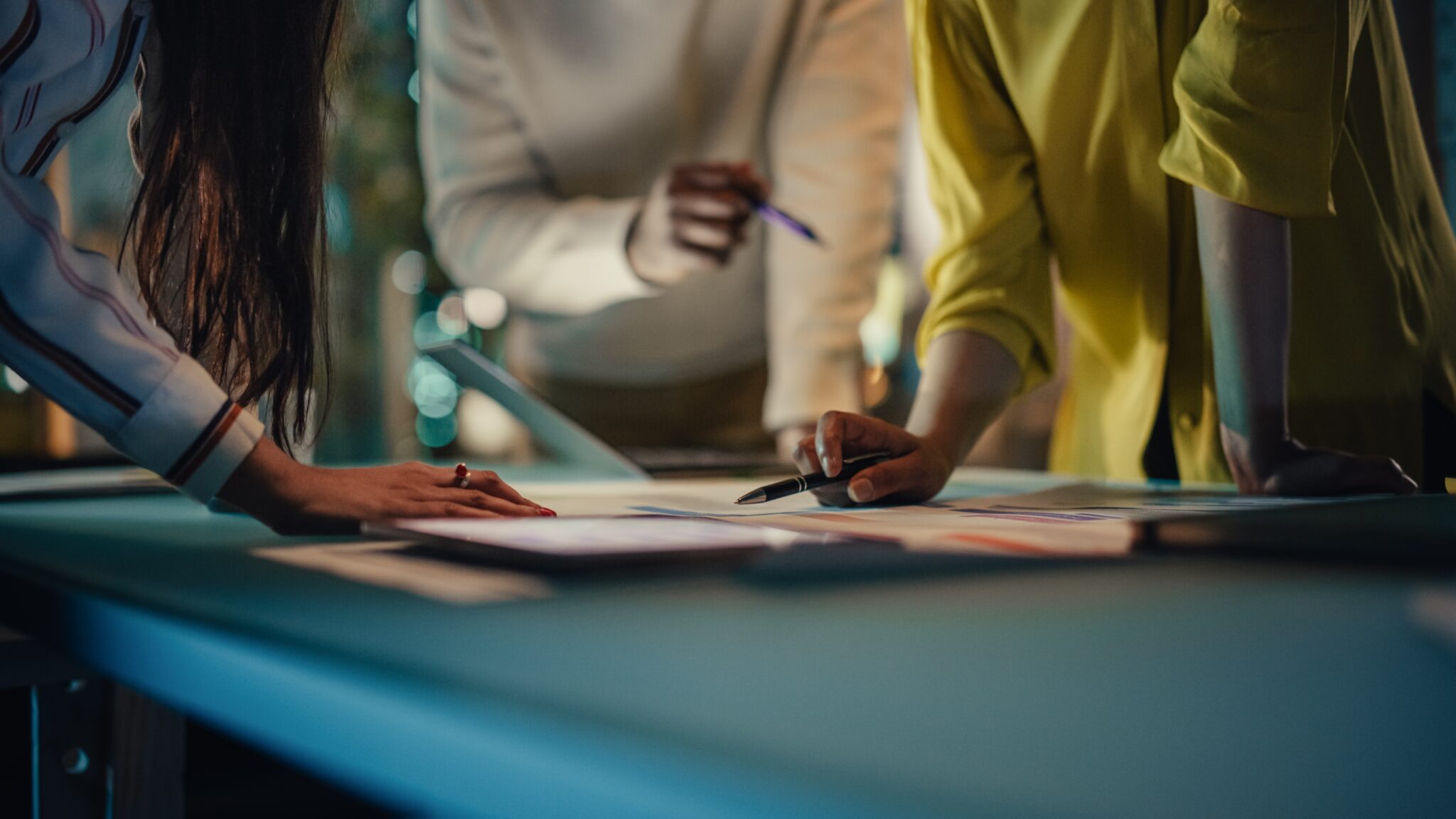 Corporate professionals overlooking a project over a table and collaborating, one of the essential power skills